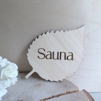 Puinen koivunlehti-saunakyltti tekstillä Sauna