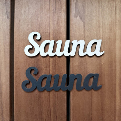 Puinen SAUNA-kyltti saunan oveen luonnonvärisenä ja mustana