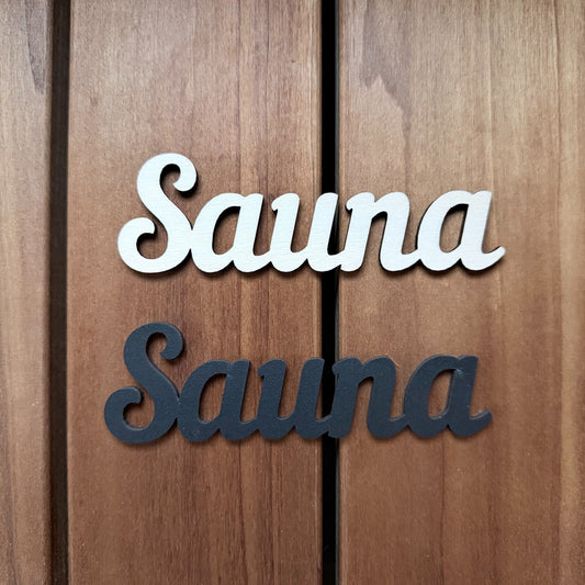 Puinen SAUNA-kyltti saunan oveen luonnonvärisenä ja mustana